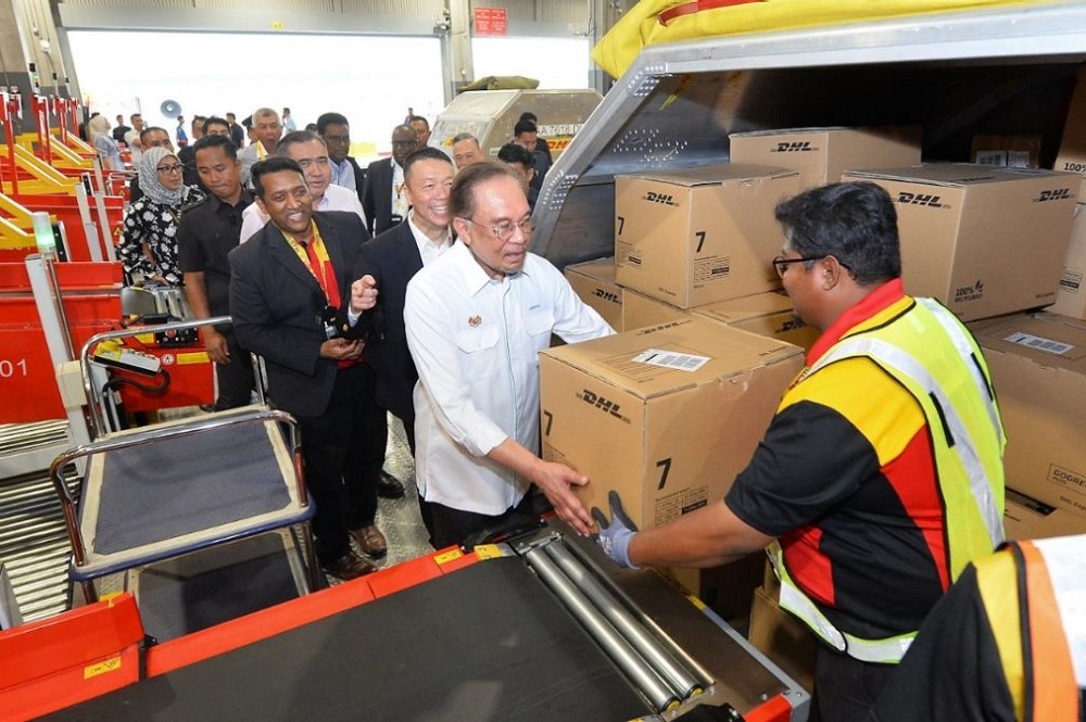 Malaysian Prime Minister Anwar bin Ibrahim loads a DHL package at the Kuala Lumpur gateway opening event